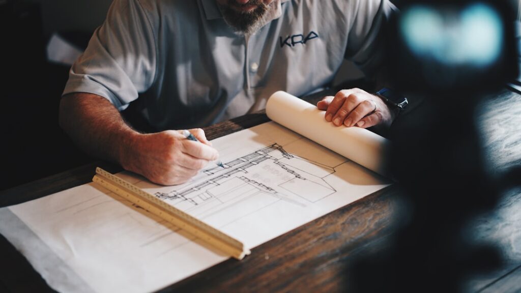 Architect or quantity surveyor working on a construction cost draft with pencil and ruler