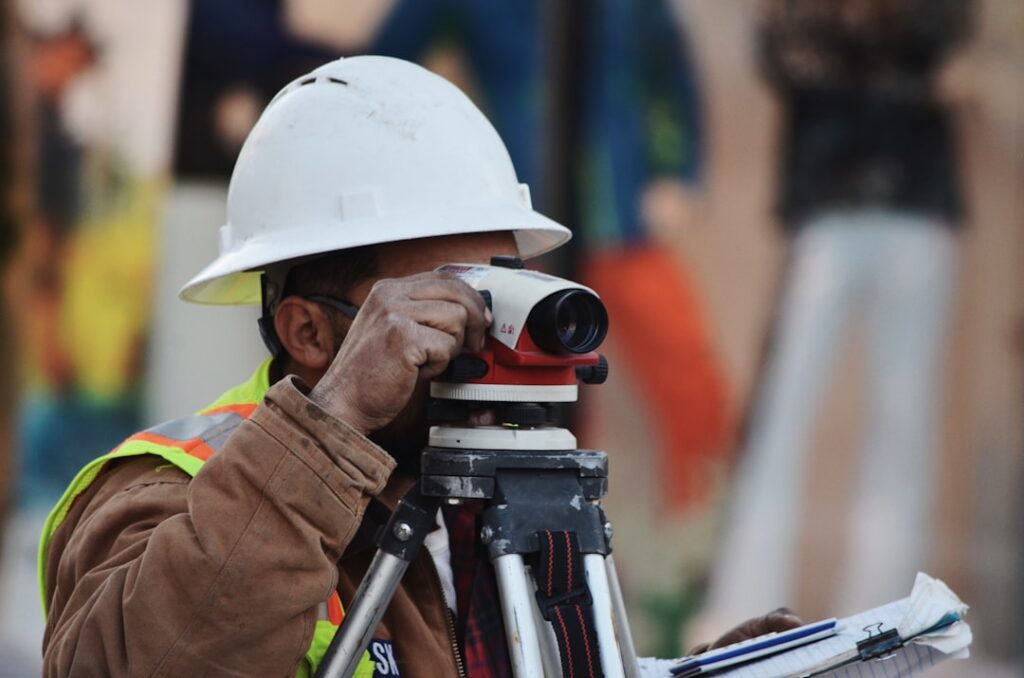 Leveling instrument set up on a tripod at a construction site